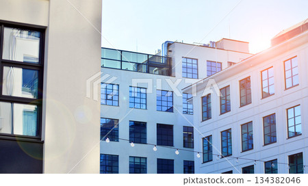 Office building in loft style. Facade of commercial office with windows. White walls of an industrial building. Office building in loft style. Facade of commercial office with windows. White walls of an industrial building. 134382046