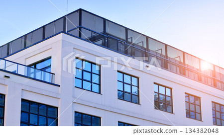 Office building in loft style. Facade of commercial office with windows. White walls of an industrial building. 134382048