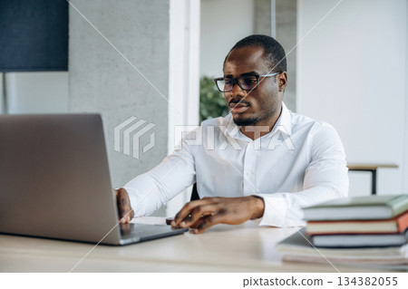 Using laptop. Businessman is working in modern office 134382055