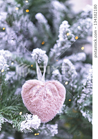 Christmas tree with pink fluffy soft heart in bokeh light decoration holiday decorations New year concept merry Christmas background greeting card 134382180