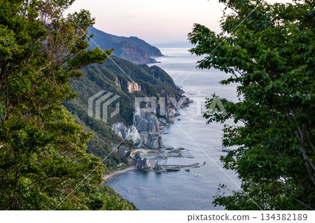 透過樹木可以看到佛陀浦嶙峋的岩石海岸和蔚藍的大海。 透過樹木可以看到佛陀浦嶙峋的岩石海岸和蔚藍的大海。 134382189