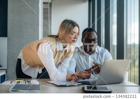 Having the conversation. Two business people are working together in the office Having the conversation. Two business people are working together in the office 134382211