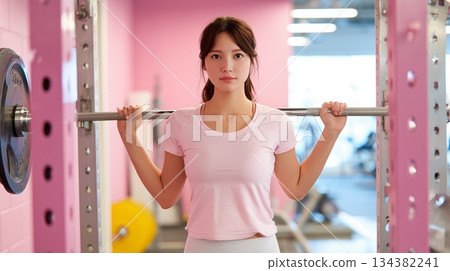 Young woman doing bench press in training gym 134382241