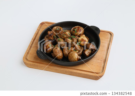 Grilled mushrooms with spices on a pan. Top view of brown champignon on pan on white background. Homemade food, healthy eating 134382548