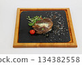 Filet Mignon steak with tomato and greens on a wooden board on a white background 134382558
