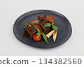 Grilled spare ribs on plate over black stone background on a white background 134382560