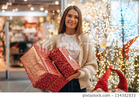 Gorgeous woman is with new year gifts near the Christmas tree 134382833