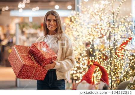 Gorgeous woman is with new year gifts near the Christmas tree Gorgeous woman is with new year gifts near the Christmas tree 134382835