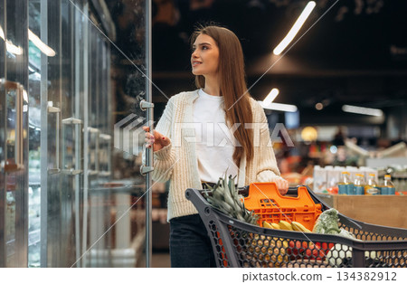 Fresh products. Beautiful woman is in the supermarket Fresh products. Beautiful woman is in the supermarket 134382912