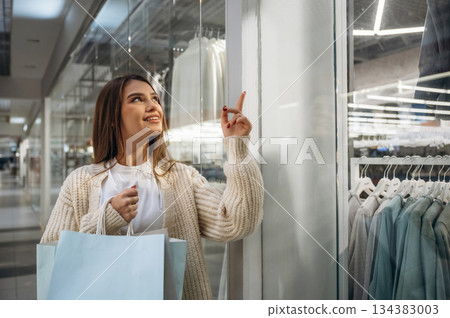 Thinking what to buy. Beautiful woman is in the mall, conception of shopping 134383003