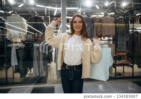 Shopping bags in hands. Beautiful woman is in the mall Shopping bags in hands. Beautiful woman is in the mall 134383007