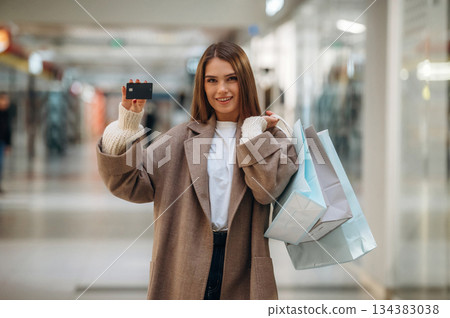 Shopping bags in hands. Beautiful woman is in the mall Shopping bags in hands. Beautiful woman is in the mall 134383038