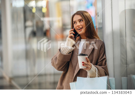 Using phone. Beautiful woman is in the mall, conception of shopping 134383043