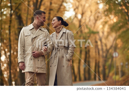 Lovely couple are together in the autumn forest near the road 134384041