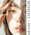 一位皮膚白皙的美麗年輕亞洲女性的特寫半臉美容/時尚鏡頭。光與影 134384246