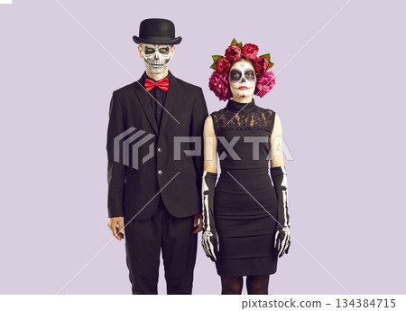Zombie lovestory. Couple in masquerade day of the dead funereal costumes standing next to each other Zombie lovestory. Couple in masquerade day of the dead funereal costumes standing next to each other 134384715