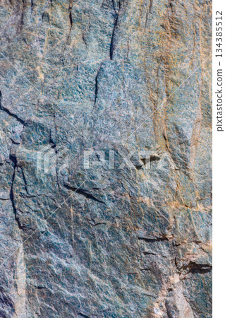 Blue green amazonite stone showing crystalline texture veins and rough surface in natural light 134385512