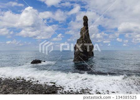Basalt monolith Ilheu da Ribeira da Janela rises near Madeira shore Atlantic waves 134385525