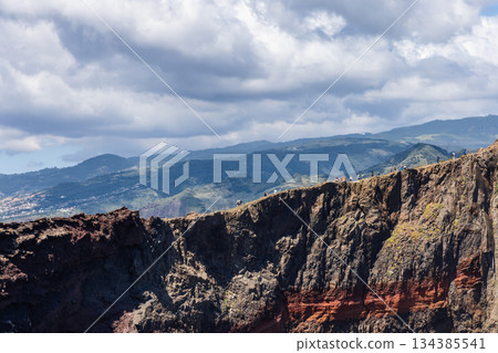 Hikers on ridge trail of Ponta de Sao Lourenco Madeira above volcanic cliffs bold strata Hikers on ridge trail of Ponta de Sao Lourenco Madeira above volcanic cliffs bold strata 134385541