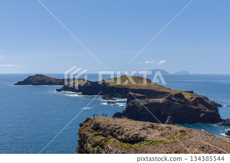Layered volcanic Sao Lourenco Madeira peninsula extends into calm Atlantic with hikers Layered volcanic Sao Lourenco Madeira peninsula extends into calm Atlantic with hikers 134385544
