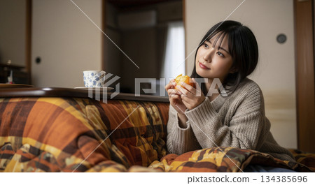 一位女士在暖桌旁放鬆休息。 134385696