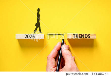 2026 Trends symbol. Concept words 2026 Trends on beautiful wooden blocks. Beautiful yellow background. Businessman holds pencil. Businesswoman icon. Business 2026 Trends new year concept. Copy space. 134386252