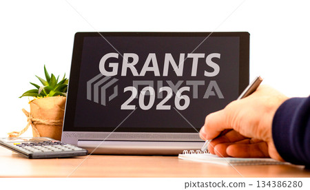 Grants 2026 symbol. Concept words Grants 2026 on beautiful black tablet screen. Beautiful white background. Businessman's hand. Business and grants 2026 concept. Copy space. 134386280