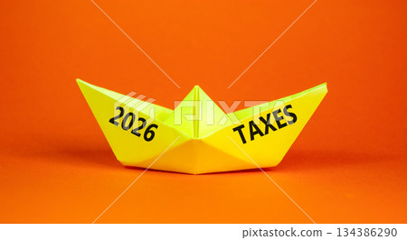 2026 taxes new year symbol. Concept words 2026 taxes on beautiful yellow paper boat. Beautiful orange paper background. Business and 2026 taxes new year concept. Copy space. 2026 taxes new year symbol. Concept words 2026 taxes on beautiful yellow paper boat. Beautiful orange paper background. Business and 2026 taxes new year concept. Copy space. 134386290
