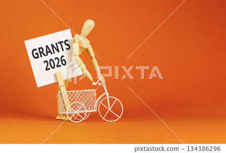 Grants 2026 symbol. Concept words Grants 2026 on beautiful white card. Beautiful orange paper background. Businessman's model. Business and grants 2026 concept. Copy space. Grants 2026 symbol. Concept words Grants 2026 on beautiful white card. Beautiful orange paper background. Businessman's model. Business and grants 2026 concept. Copy space. 134386296