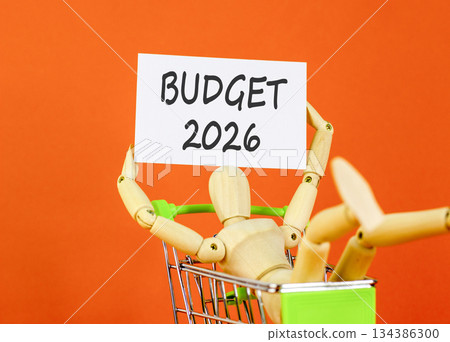 Budget 2026 symbol. Concept words Budget 2026 on beautiful white card. Beautiful orange paper background. Businessman's model. Business and budget 2026 concept. Copy space. Budget 2026 symbol. Concept words Budget 2026 on beautiful white card. Beautiful orange paper background. Businessman's model. Business and budget 2026 concept. Copy space. 134386300