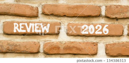 Review 2026 symbol. Concept words Review 2026 on beautiful brown brick wall. Beautiful brown brick wall background. Business and review 2026 concept. Copy space. 134386313