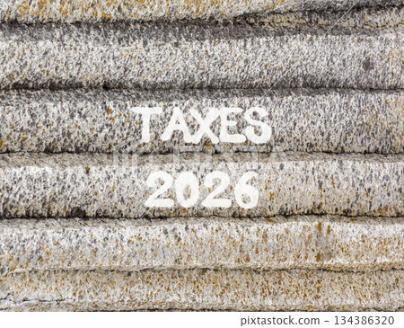 Taxes 2026 new year symbol. Concept words Taxes 2026 on beautiful grey mountain wall. Beautiful grey mountain wall background. Business and taxes 2026 new year concept. Copy space. 134386320