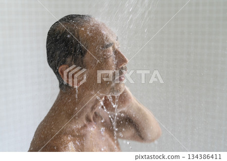 A man in his early 60s taking a shower, profile A man in his early 60s taking a shower, profile 134386411