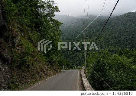The road leading down. Incredible view of the mountains, clouds in the mountains The road leading down. Incredible view of the mountains, clouds in the mountains 134386813