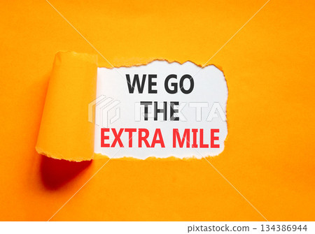 Support, help we go the extra mile symbol. Concept words We go the extra mile on beautiful white paper. Beautiful orange paper background. Business we go the extra mile concept. Copy space. 134386944