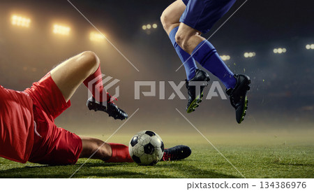 Explosive ground tackle with professional players fighting for ball on pitch Explosive ground tackle with professional players fighting for ball on pitch 134386976