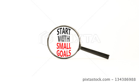 Start with small goals symbol. Concept words phrase Start with small goals in beautiful black magnifying glass. Beautiful white background. Business Start with small goals concept. Copy space. 134386988