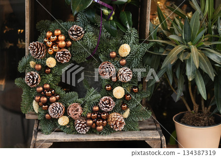 Christmas wreath with branches cones and golden balls 134387319