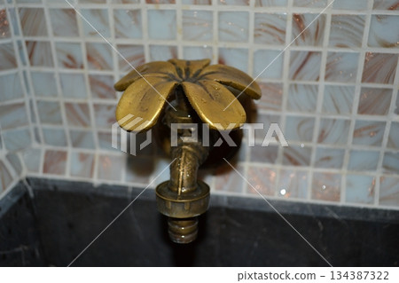 A vintage petal-shaped tap with cold and hot water in a bathroom A vintage petal-shaped tap with cold and hot water in a bathroom 134387322