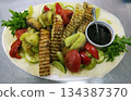Baked sturgeon steaks with fresh salad greens 134387370