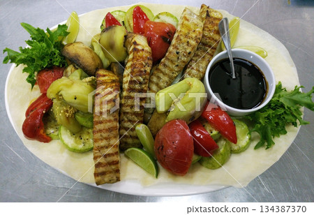 Baked sturgeon steaks with fresh salad greens 134387370