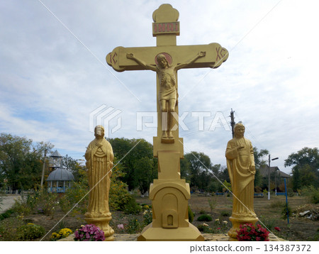 An Orthodox cross with the crucifixion of Jesus Christ stands on a pedestal 134387372