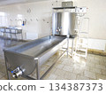 A cylindrical metal tank connected to a long rectangular bath. 134387373