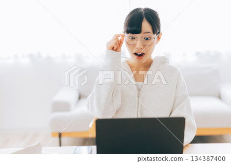 A woman using a personal computer at home A woman using a personal computer at home 134387400