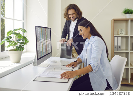 Business people at work in office on workplace. Company employees analyzing company finance data. Business people at work in office on workplace. Company employees analyzing company finance data. 134387538