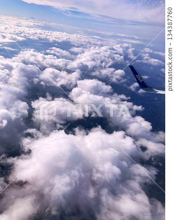 從飛機舷窗望出去，可以看到一片雲海，遠處是富士山。 134387760