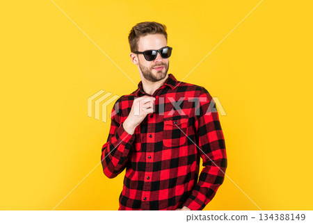 young handsome man in checkered shirt and sunglasses has bristle on face, summer young handsome man in checkered shirt and sunglasses has bristle on face, summer 134388149