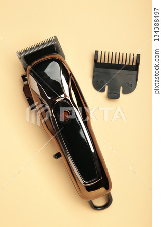 Hair clipper on beige background. Modern hair clipper. Vertical photo Hair clipper on beige background. Modern hair clipper. Vertical photo 134388497