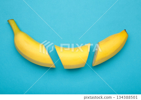 Cut banana, slices on pastel blue background. Minimalist concept. Cut banana, slices on pastel blue background. Minimalist concept. 134388501
