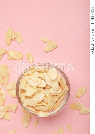 Fresh almond flakes in bowl on pink background. Vertical photo Fresh almond flakes in bowl on pink background. Vertical photo 134388533